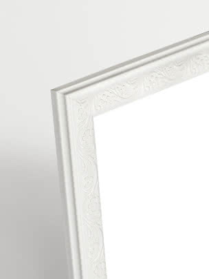 Close-up of white Versailles picture frame with decorative floral pattern
