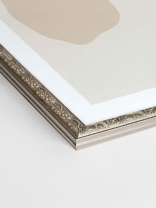 Close-up of silver Versailles picture frame with ornate pattern and white mat border