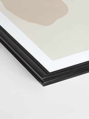 Gros plan sur un cadre photo noir avec passe-partout blanc et impression beige