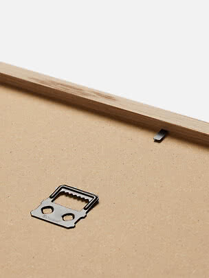 Close-up of the back of a wooden frame with metal hanging hardware