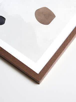 Abstract art print in dark wood frame with white border and organic beige and black shapes
