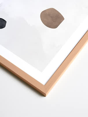 Abstract print in a light wood frame with white space and organic brown and black shapes