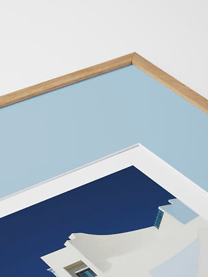 Close-up of framed art print with light wood frame and blue detail