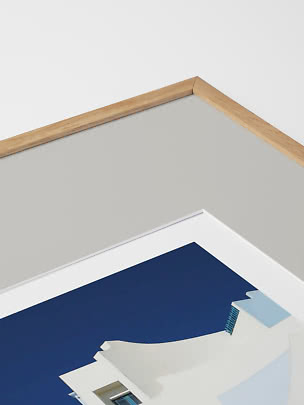 Close-up of the corner of a framed print with a light wood frame