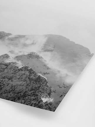 Póster en blanco y negro de picos nevados entre la niebla