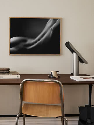Indrammet sort-hvid kunstprint af abstrakt kropsform over et skrivebord