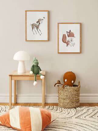 Kids room with two animal posters, table lamp, green knitted doll and basket with octopus plush