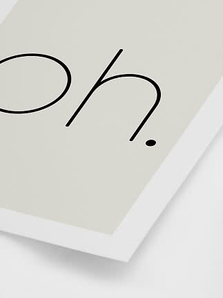 Primo piano di stampa minimalista con scritta nera su sfondo chiaro in cornice bianca