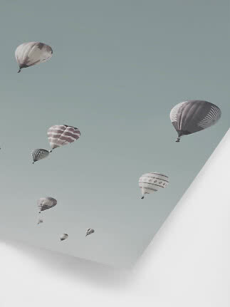 Decke mit mehreren Heißluftballons vor hellblauem Himmel
