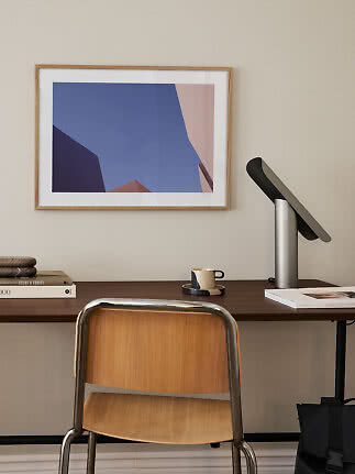 Schreibtisch mit Stuhl, Tischlampe und gerahmtem abstraktem Bild an der Wand