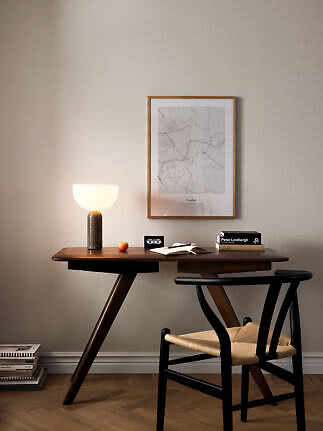 Dunkler Holzschreibtisch mit leuchtender Tischlampe, Stuhl und gerahmter London-Karte an der Wand
