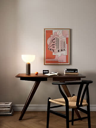 Dunkler Holzschreibtisch mit Tischlampe, Büchern und Stuhl unter gerahmtem Poster