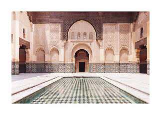 Courtyard with ornate arches, mosaic walls and a rectangular reflecting pool