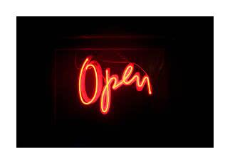 Letrero de neón rojo con la palabra "Open" sobre fondo oscuro