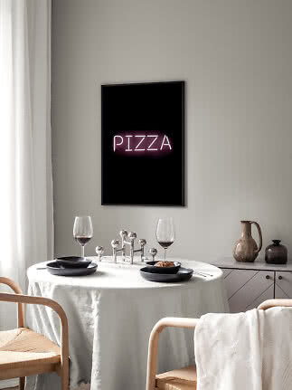Framed poster with pink neon "PIZZA" text above a set dining table
