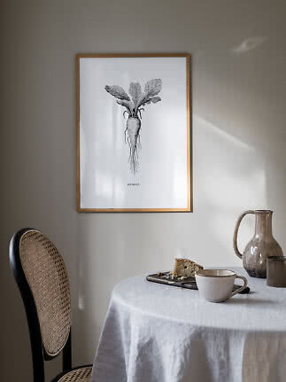 Framed botanical beetroot print on wall above a table with cup, cake and ceramic jug