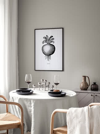 Framed black-and-white kohlrabi poster above a set dining table in a light Scandinavian room