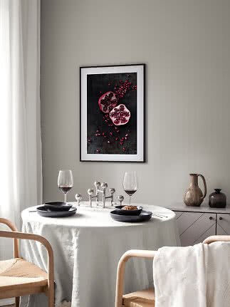 Affiche encadrée de grenade au-dessus d'une table dressée dans une pièce lumineuse