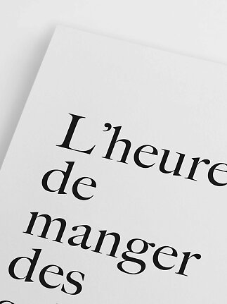 Primo piano di un poster bianco con tipografia nera e testo in francese
