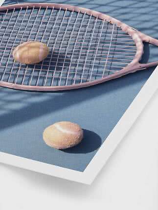 Raquette de tennis rose avec deux balles sur un court bleu