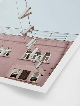 Foto artística de edificio rosa con ventanas y lámparas colgantes, vista desde abajo