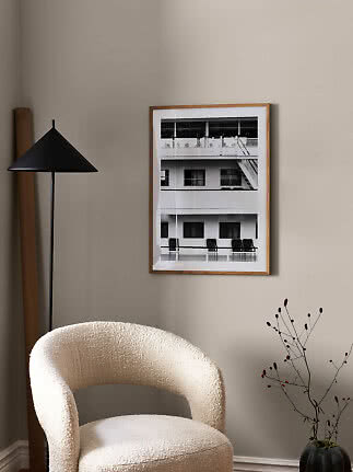 Living room corner with cream armchair, black floor lamp and framed black-and-white wall art