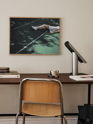 Wooden desk with chair, lamp, and framed wall art