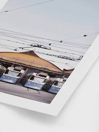 Poster mit drei blauen Straßenbahnen vor einem Depot unter Oberleitungen
