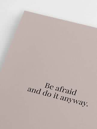 Lyserød plakat med sort tekst: "Be afraid and do it anyway."