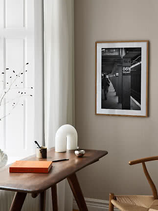 Photo noir et blanc encadrée de 86 Street sur mur beige au-dessus d'un bureau en bois