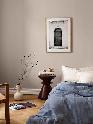 Framed black-and-white photo of a classic doorway above a bed in a calm bedroom