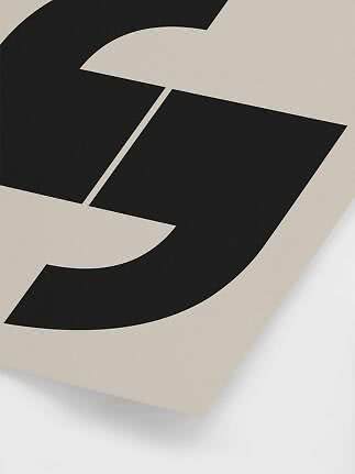 Abstraktes schwarzes geometrisches Motiv auf beigem Poster, schräg fotografiert