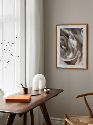 Stampa d’arte astratta beige incorniciata sulla parete sopra una scrivania in legno