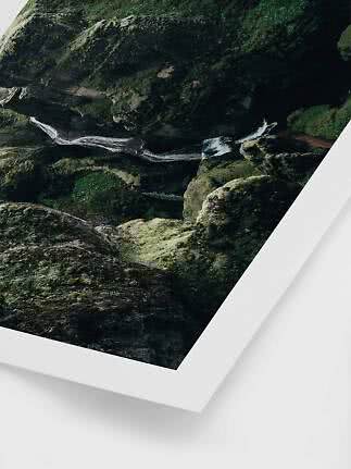 Luftfoto af lille vandfald gennem mosdækkede klipper, trykt som plakat med hvid kant