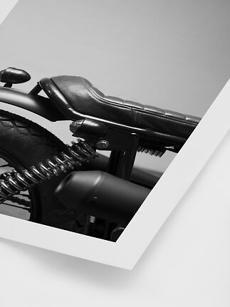 Primo piano di sella moto nera con ruota posteriore, molla e scarico