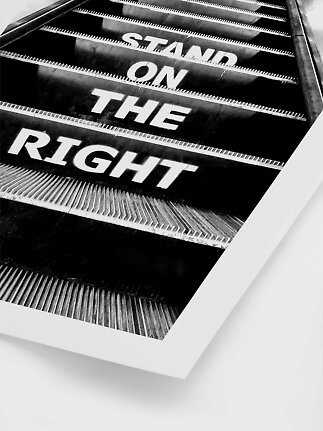 Czarno-biały plakat ruchomych schodów z napisem „Stand on the right” na stopniach