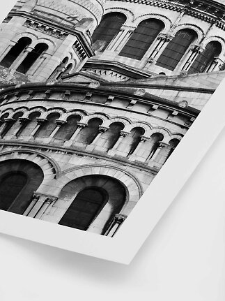 Black-and-white photo of a historic stone building with arched windows and ornate arcades