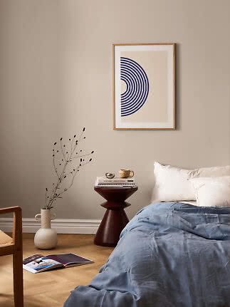 Gerahmter abstrakter Print mit blauen Halbkreisen über einem Bett im beigen Schlafzimmer