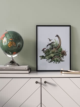 Indrammet dinosaurplakat på kommode ved siden af en globus.
