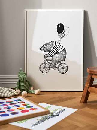 Gerahmtes Schwarz-Weiß-Poster mit einem Bären auf dem Fahrrad mit Ballons, an eine Kinderzimmerwand gelehnt