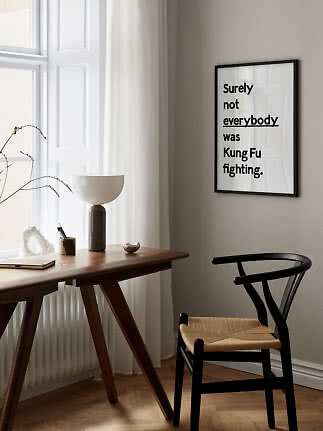 Gerahmtes Typografie-Poster mit dem Text „Surely not everybody was Kung Fu fighting“ an beiger Wand