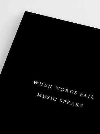 Czarny plakat z białym napisem: "When words fail music speaks"