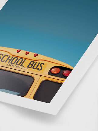 Close-up of the top of a yellow school bus against a clear blue sky