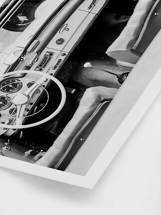 Sort-hvidt foto af interiøret i en klassisk cabriolet med rat, instrumentbræt og sæder