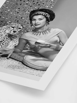 Black-and-white photo of an elegant woman with jewelry and a cheetah beside her
