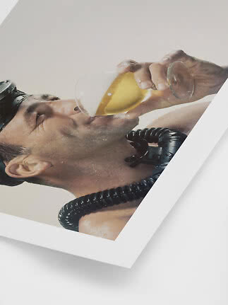 Man met duikbril en snorkel drinkt uit een wijnglas met gouden drank