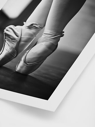 Primo piano in bianco e nero di piedi di ballerina con scarpe da punta e nastri