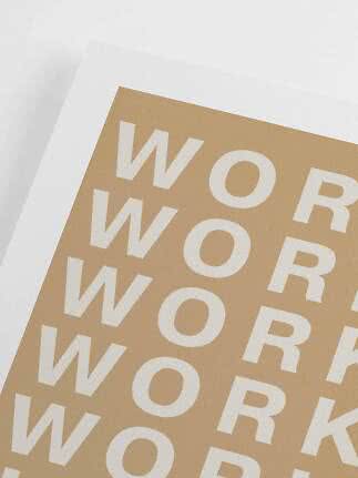 Close-up of beige poster with repeated white WORK text and wide white border