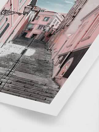 Ripida scalinata in pietra tra edifici rosa in una strada stretta