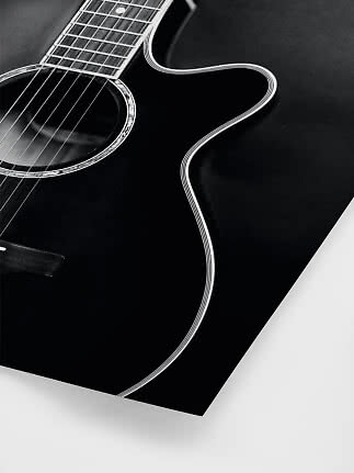 Close-up of a black acoustic guitar with cutaway and glossy finish